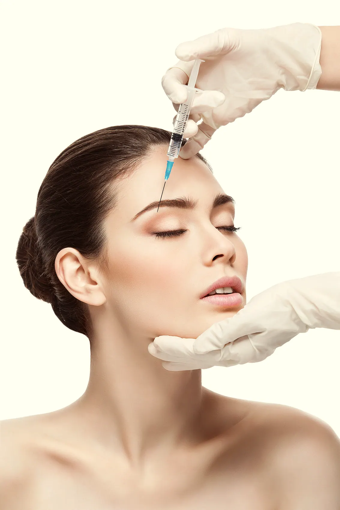 Injector marking a client's forehead before treatment